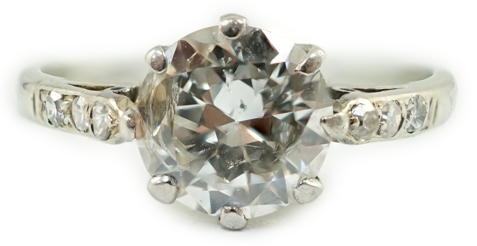 A platinum and single stone diamond ring, with diamond set shoulders